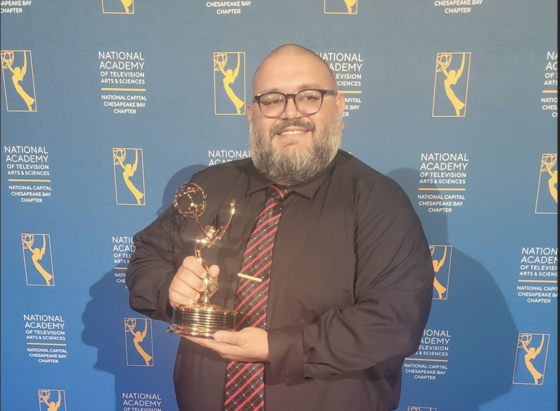 Paul Rosado receiving Emmy for his work