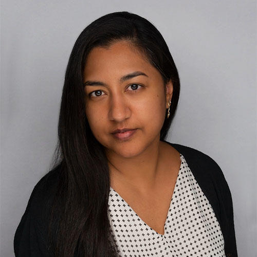 Miriam Ahmed, a middle-eastern woman with long dark hair and dark eyes dressed in black and shite