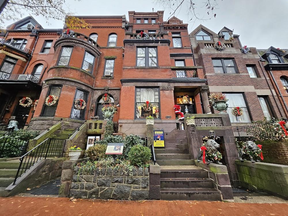 O Museum in Washington D.C.: large red brick building accessed up gray stone steps with many colorful flower wreaths on windows