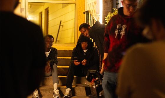 A group of people on a film set. In the center, James Bah gives direction to an actor